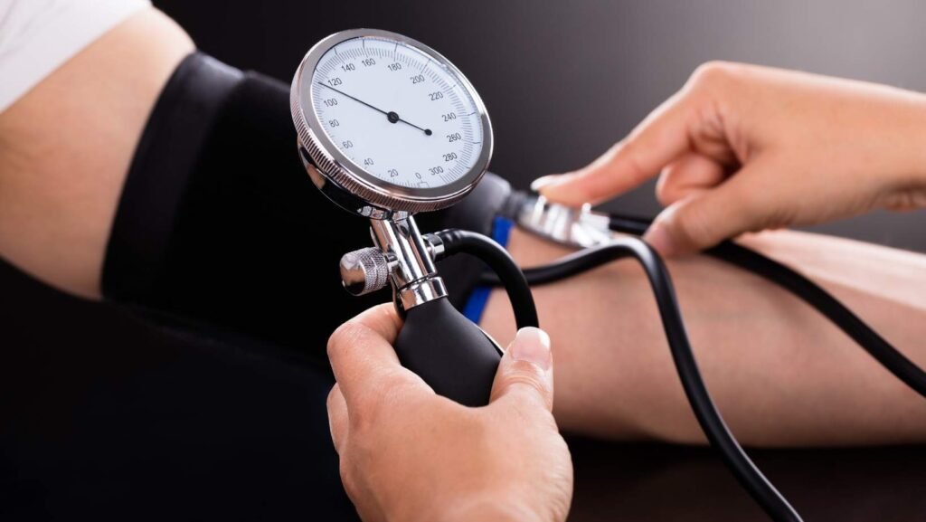 Imagem mostrando um profissional aferindo a Pressão arterial de um paciente.