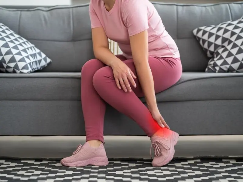 Uma mulher sentindo dor no calcanhar ao caminhar por causa da Fasceíte Plantar