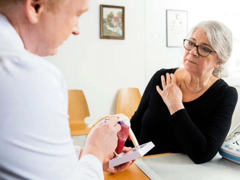 médico explicando para a paciente sobre a Tendinite do Supraespinhoso
