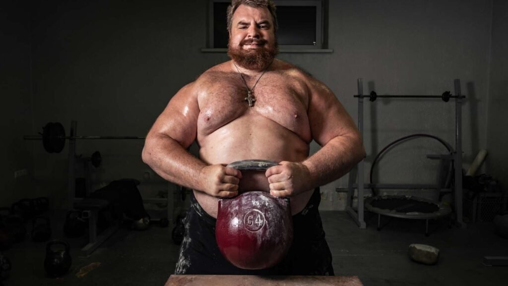 Um homem forte segurando um Kettlebell pesado