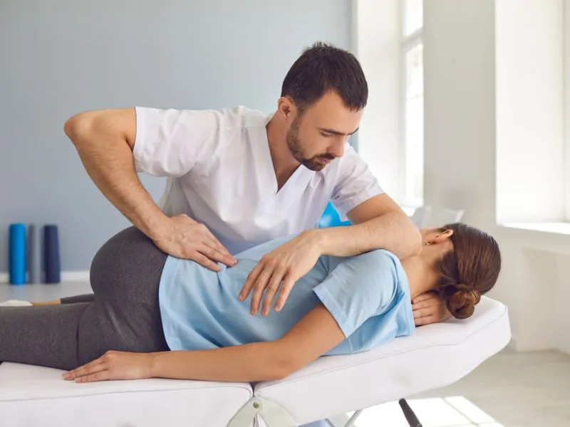 Fisioterapeuta fazendo fisioterapia na coluna lombar do paciente